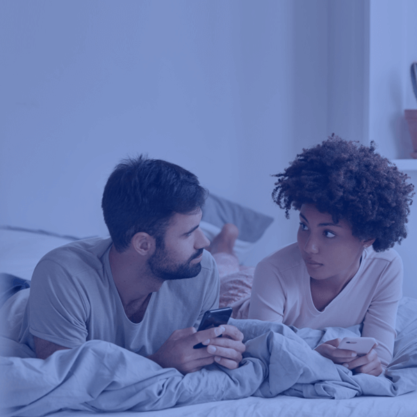 Couple in bed checking moving regulations